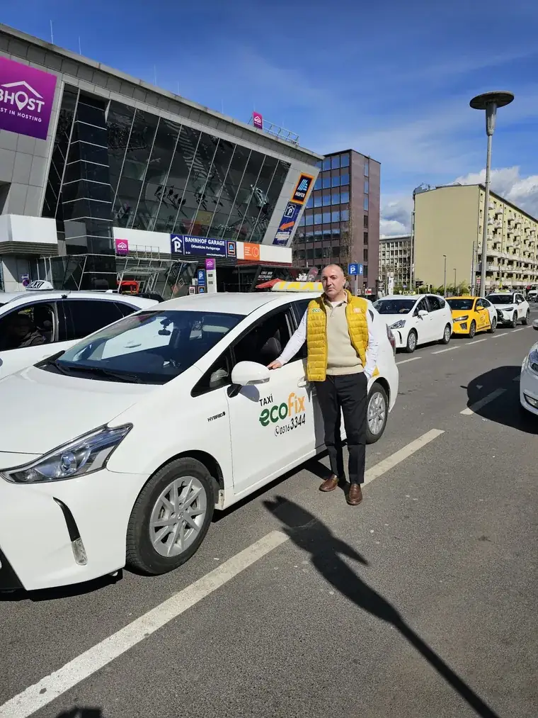 EcoFix Fahrer vor einem weißen Taxi am Grazer Hauptbahnhof